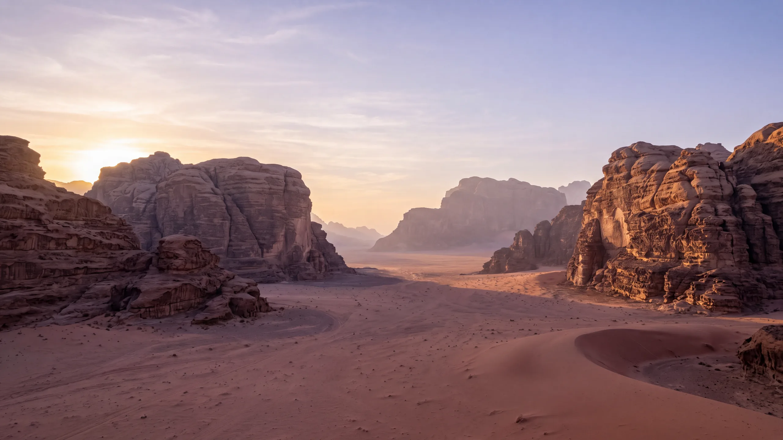 AI-created interpretation of Wadi Rum in Jordan at sunset, with red sand, weathered sandstone massifs and long soft shadows beneath a pale amber and lavender-blue sky.